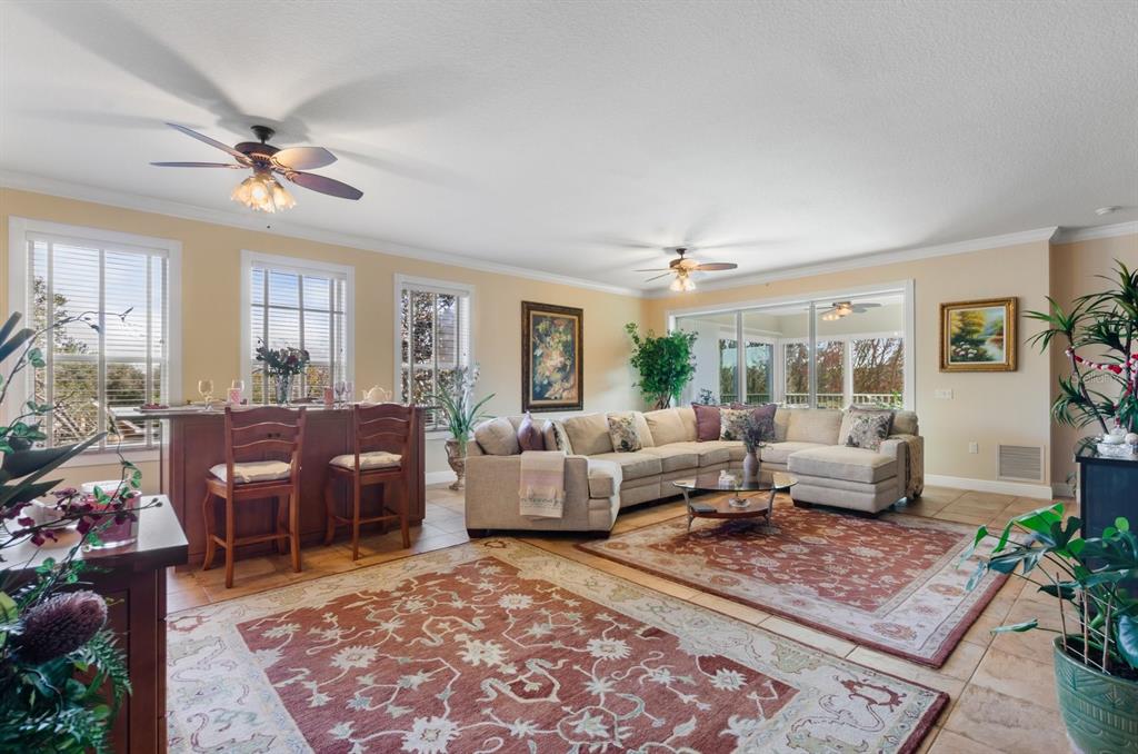 A spacious living room features a large sectional sofa, two area rugs, and a breakfast bar — 5209 MANORWOOD DRIVE UNIT 3A, SARASOTA, FL