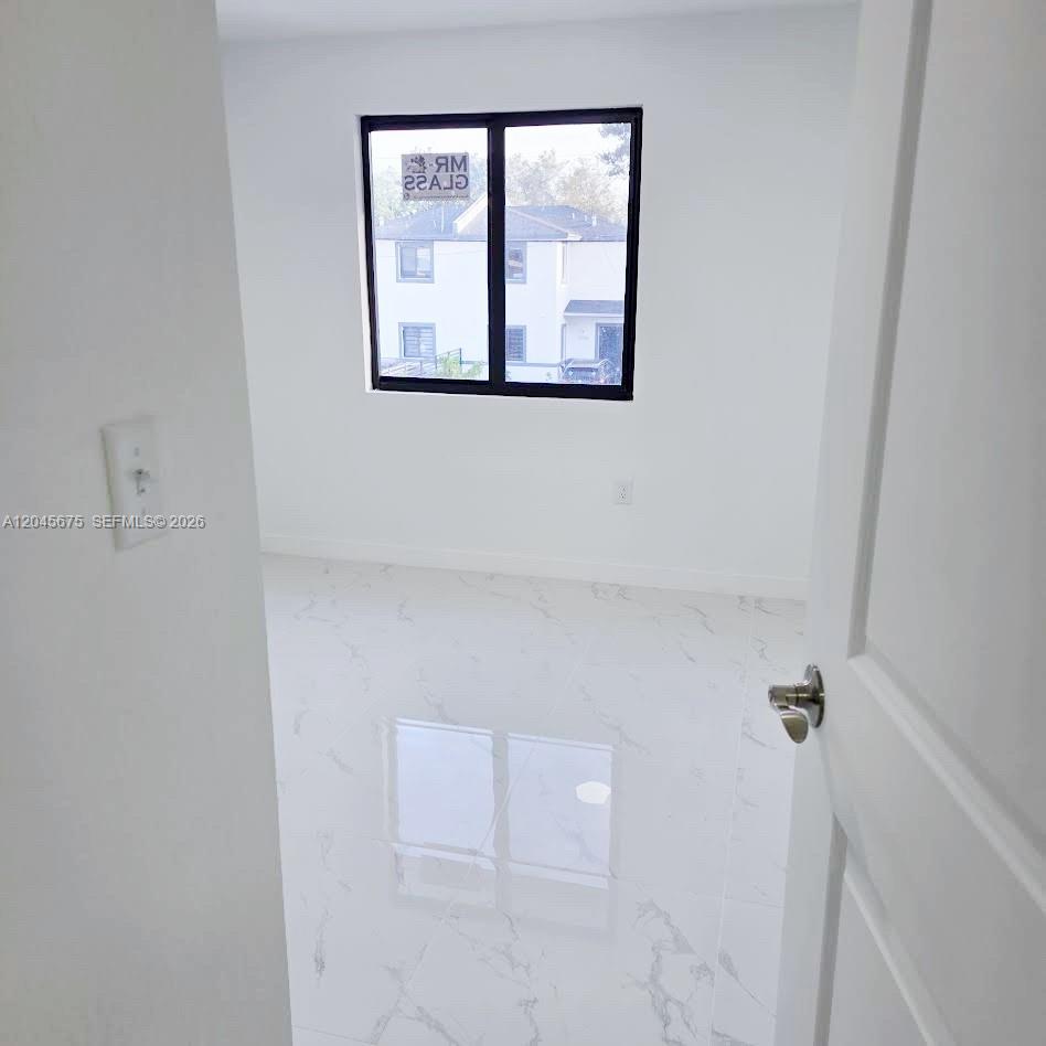 A small room with white walls, a single window, and white marble-patterned tile flooring — 2731 NW 44th St # 2731, Miami FL 33142, MIAMI, FL