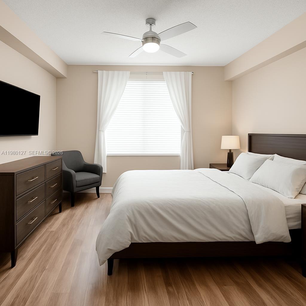 A bedroom features a bed, a dresser, a gray armchair, and a ceiling fan — 1900 Van Buren St # 112B, Hollywood FL 33020, HOLLYWOOD, FL