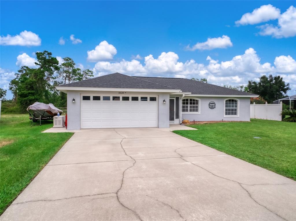 An aerial view of a gray single-story house with a dark roof and attached garage — 2630 GRESHAM STREET, SEBRING, FL