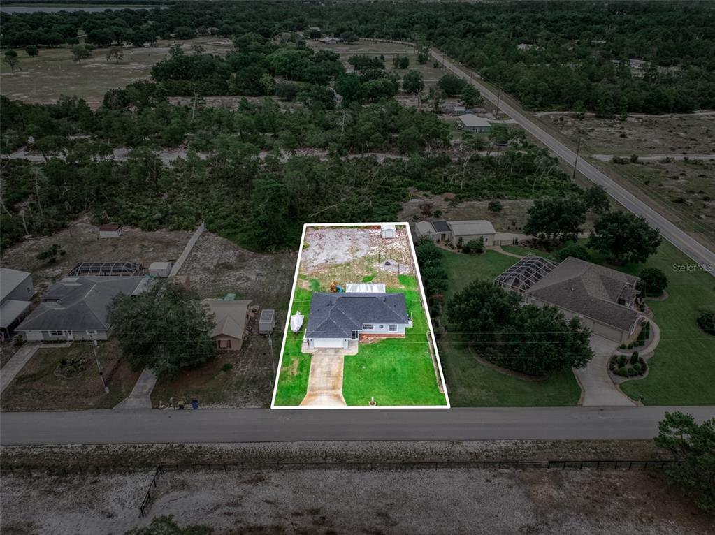 An aerial view shows a single-story house with a white outline on its property lot — 2630 GRESHAM STREET, SEBRING, FL