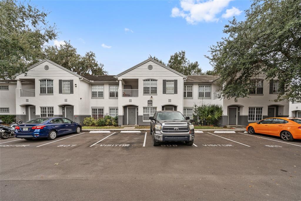 A two-story apartment building exterior with a parking lot in the foreground — 4356 S KIRKMAN ROAD UNIT 514, ORLANDO, FL