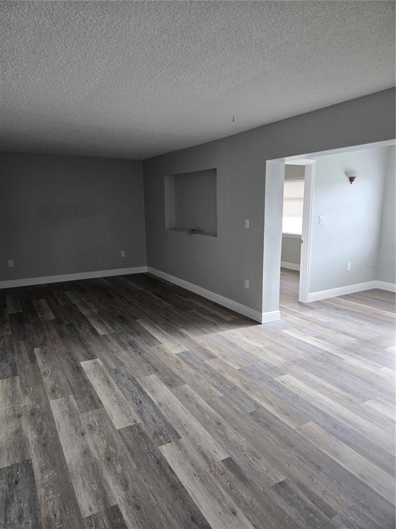 An empty room with gray walls, wood-look flooring, and a recessed wall niche — 4600 MARINE PARKWAY UNIT 107, NEW PORT RICHEY, FL