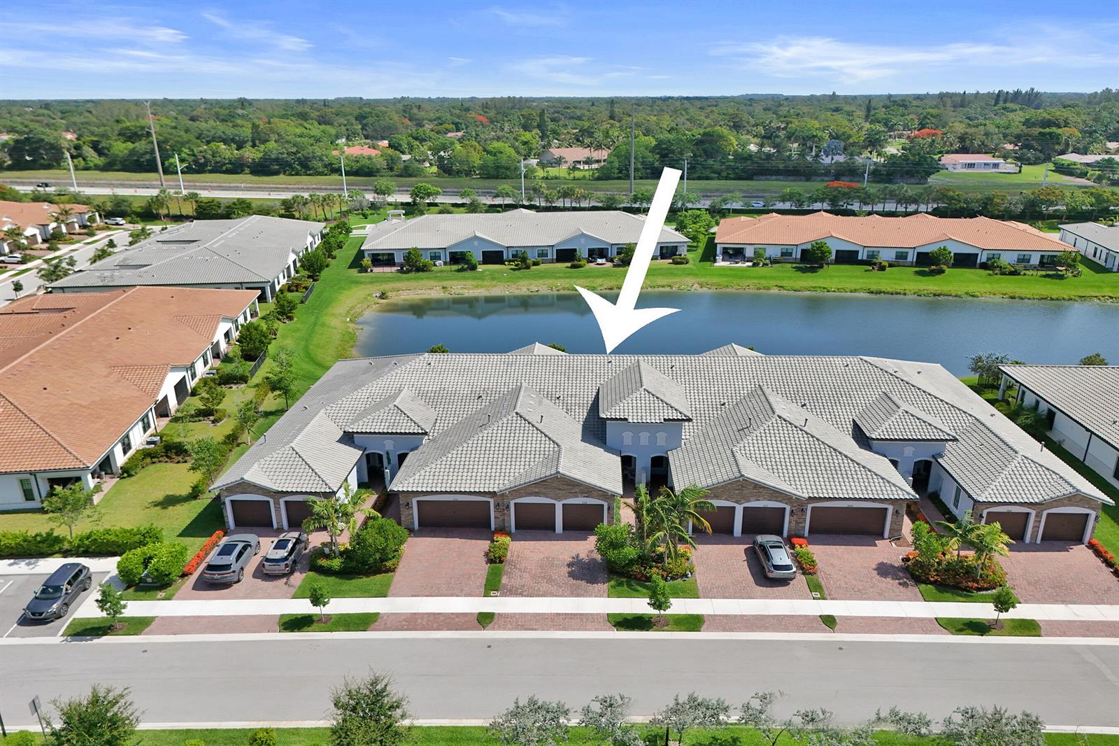 An aerial view shows a multi-unit residential building with a tiled roof and attached garages — 7719 S Blue Spring Drive, Parkland FL 33067, PARKLAND, FL