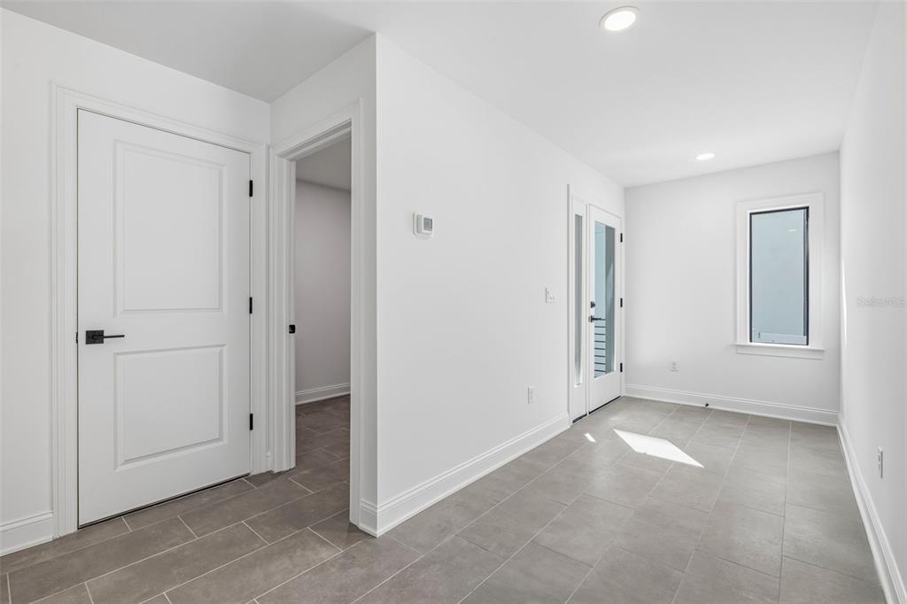 A bright entryway features white walls, gray tile flooring, a glass-paneled door, and a window — 4509 W NORTH A STREET UNIT 2, TAMPA, FL