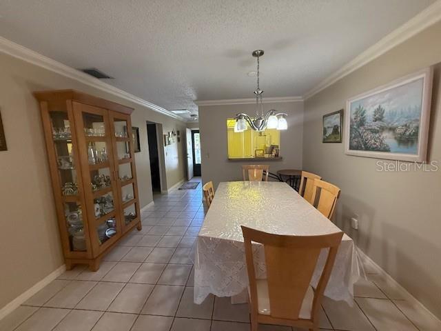 A dining room features a wooden china cabinet, a table with chairs, and a chandelier — 2664 WOODGATE LANE UNIT D2, SARASOTA, FL