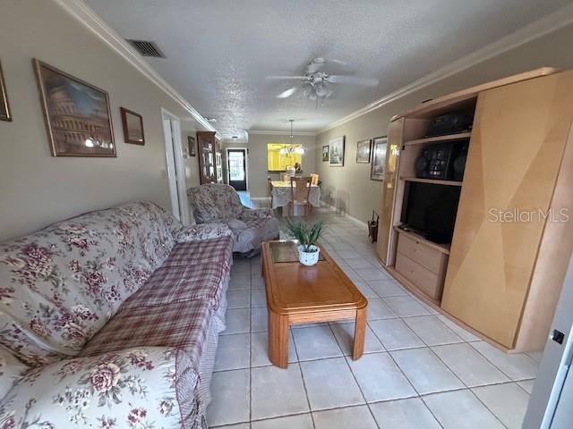 A living room features a floral sofa, a wooden coffee table, and a large entertainment center — 2664 WOODGATE LANE UNIT D2, SARASOTA, FL