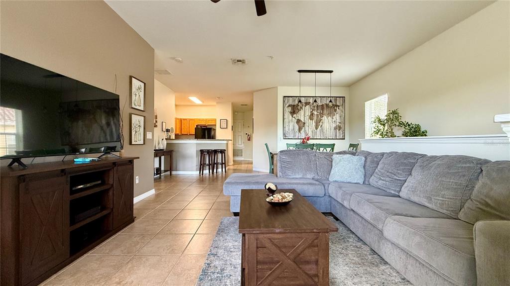 A living room with a large sectional sofa, coffee table, and television on a console — 2831 OAKWATER DRIVE UNIT 2831, KISSIMMEE, FL