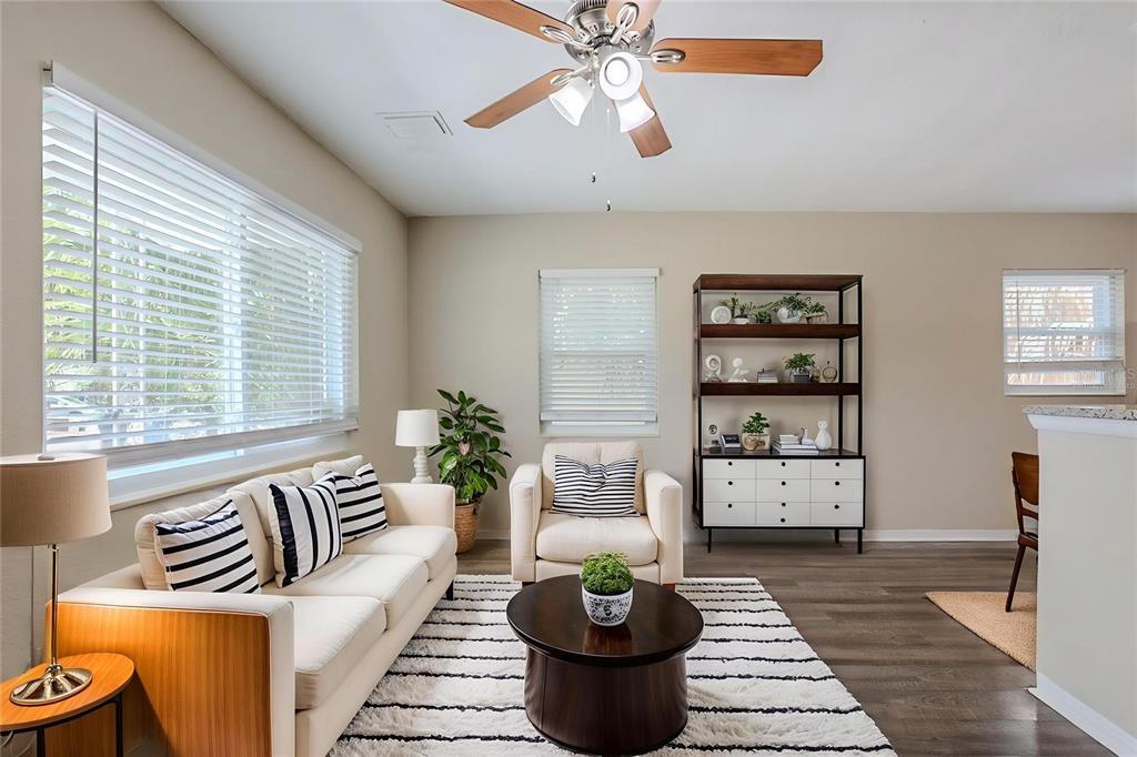 A living room features a white sofa, an armchair, a coffee table, and a bookshelf — 4111 13TH AVENUE S, ST PETERSBURG, FL