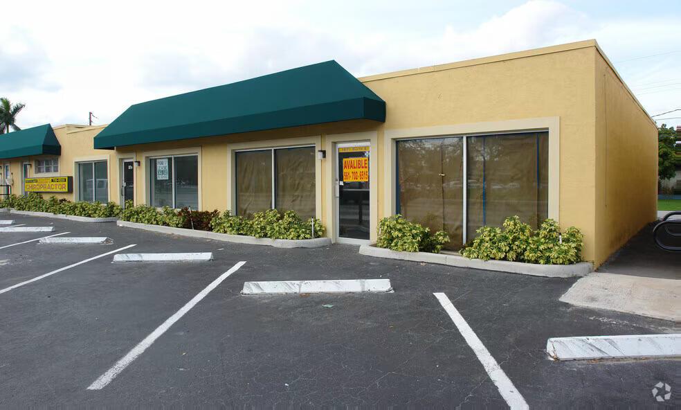 A yellow commercial building with a green awning and a for lease sign in the window — OAKLAND PARK, FL