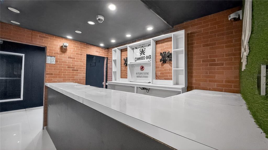 A bar area features a white counter, brick walls, and a branded display shelf — Urb. La Rosaleda EA10 AVE. BOULEVARD MONROIG, TOA BAJA, PR