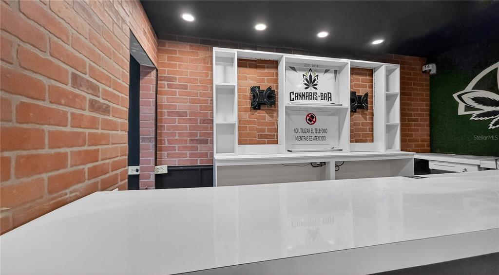 A home bar features a white countertop, brick walls, and a custom shelving unit — Urb. La Rosaleda EA10 AVE. BOULEVARD MONROIG, TOA BAJA, PR