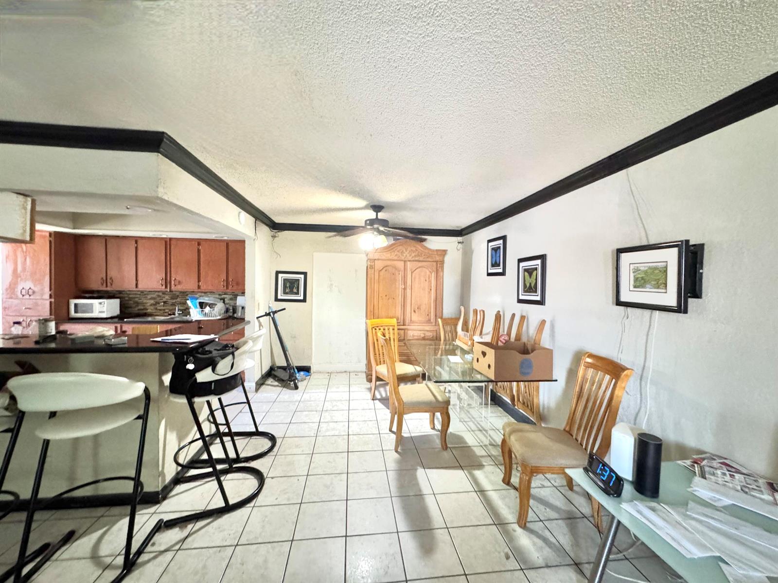 A dining area with a glass table and chairs sits adjacent to a kitchen counter — 4310 NE 1st Terrace, Pompano Beach FL 33064, POMPANO BEACH, FL