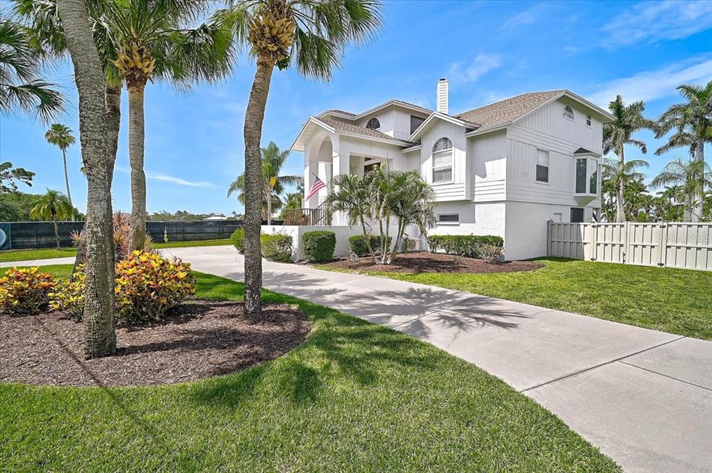 A two-story white house with a concrete driveway, two-car garage, and palm trees — 320 RINGLING POINT DRIVE, SARASOTA, FL