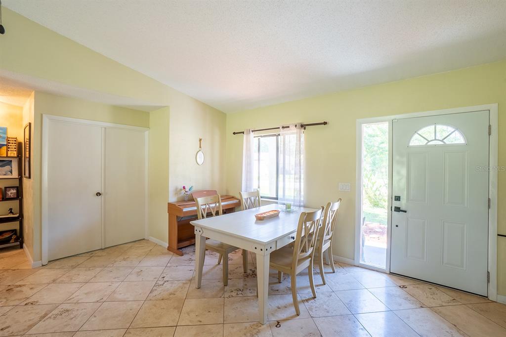 A dining area features tile flooring, a white table with four chairs, and a front door — 25 ETHAN ALLEN DRIVE, PALM COAST, FL