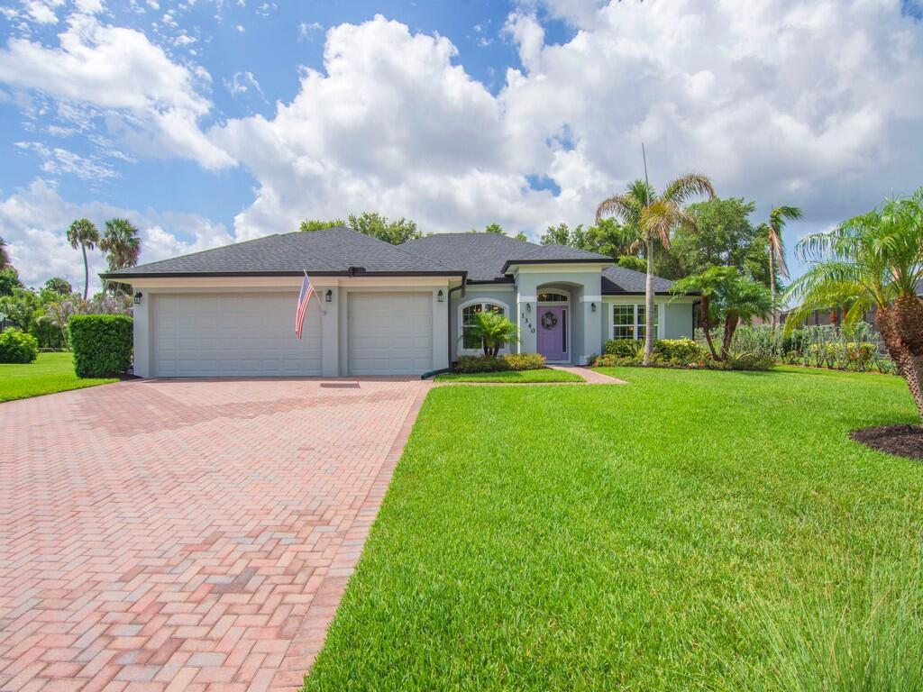 A single-story house with a two-car garage, brick paver driveway, and a purple front door — 1340 Willow Oak Court, Vero Beach FL 32966, VERO BEACH, FL