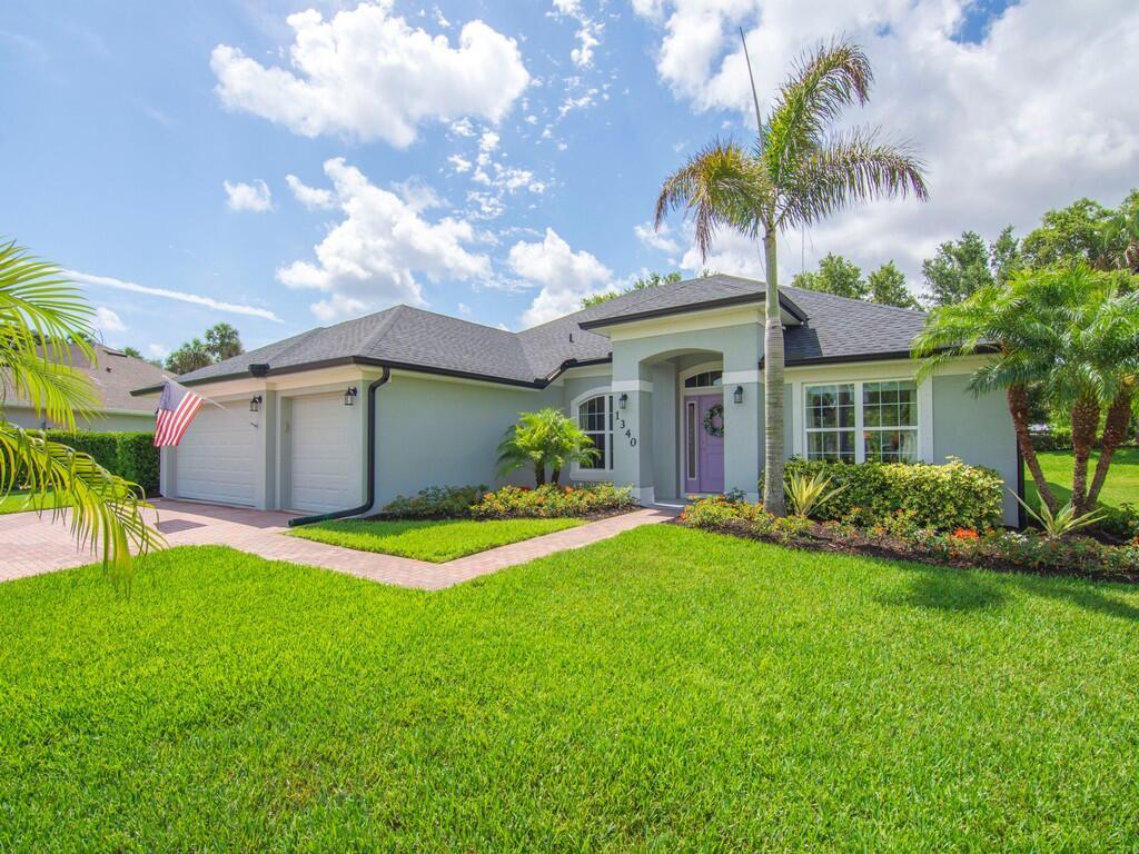A single-story house with a light green exterior, a purple front door, and a palm tree — 1340 Willow Oak Court, Vero Beach FL 32966, VERO BEACH, FL