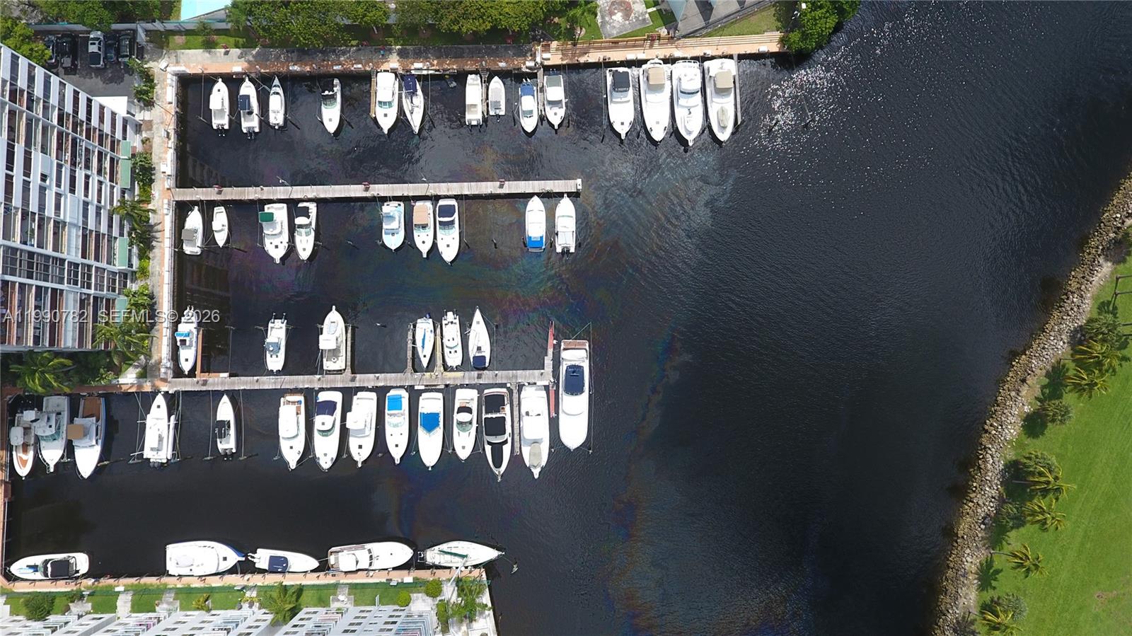 An aerial view shows a marina with numerous boats docked along wooden piers — 1700 NW North River Dr, Miami FL 33125, MIAMI, FL
