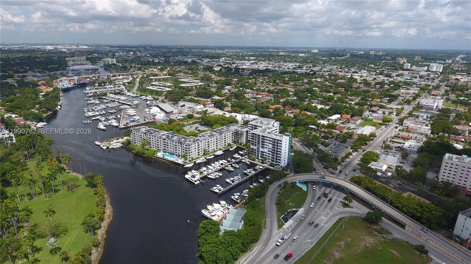 An aerial view shows a waterway with a marina, apartment buildings, and a highway overpass — 1700 NW North River Dr, Miami FL 33125, MIAMI, FL