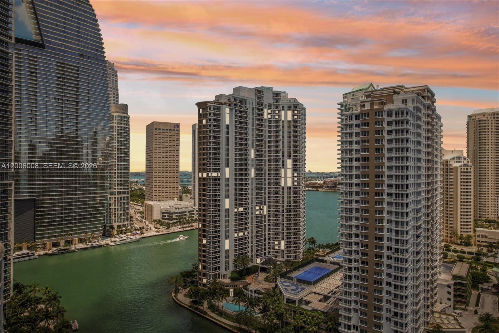 An aerial view of high-rise apartment buildings overlooking a canal and city skyline at sunset — 901 Brickell Key Blvd # 1009, Miami FL 33131, MIAMI, FL