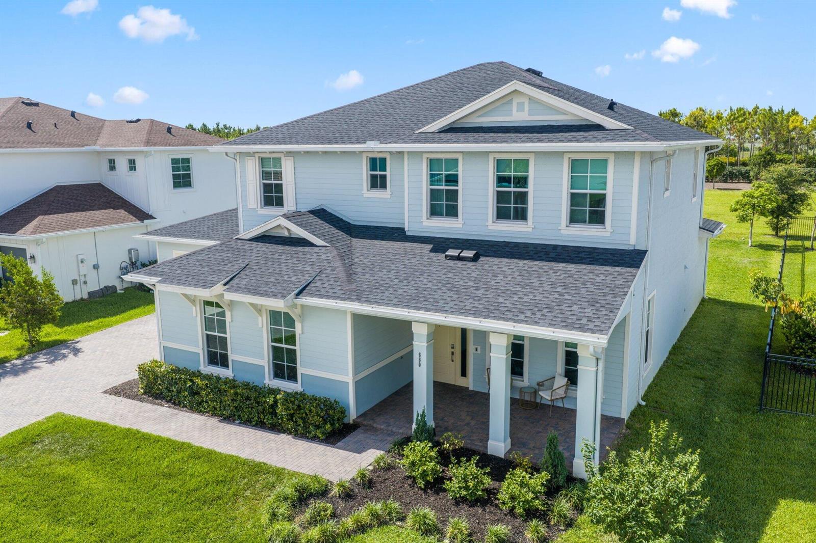 An aerial view of a two-story light blue house with a covered front porch — 660 Hookline Circle, Loxahatchee FL 33470, LOXAHATCHEE, FL