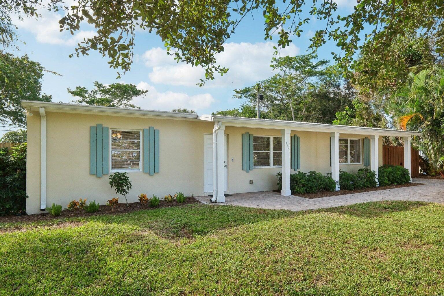 A single-story house with light-colored stucco walls, blue shutters, and a covered front porch — 1455 15th Avenue, Vero Beach FL 32960, VERO BEACH, FL