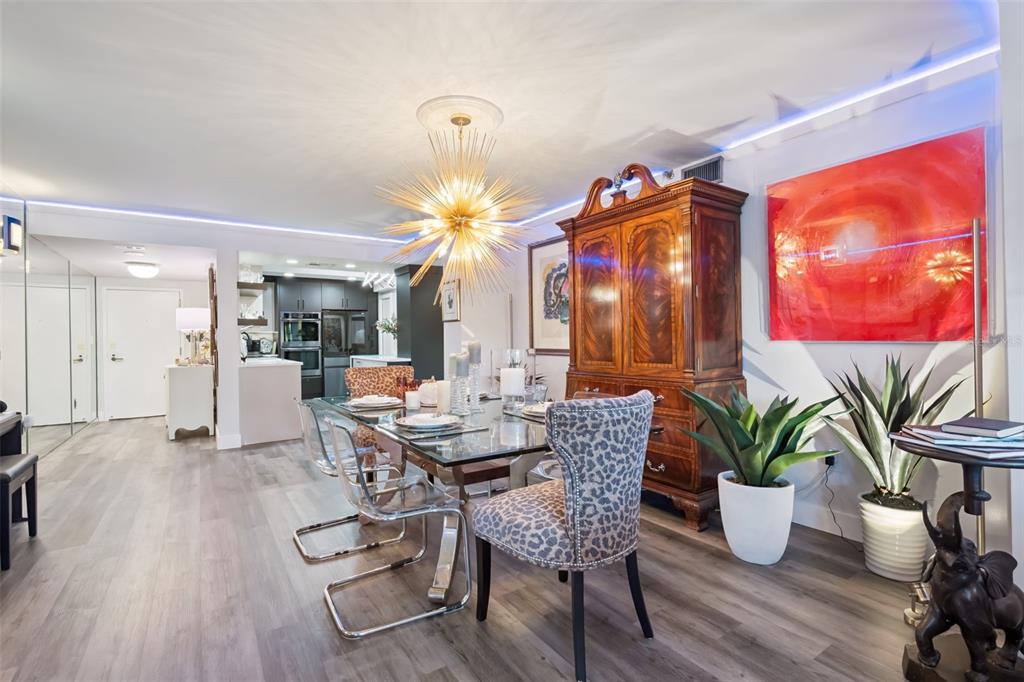 A dining room features a glass table, leopard-print chairs, a wooden armoire, and a starburst chandelier — 7550 HINSON STREET UNIT 4b, ORLANDO, FL