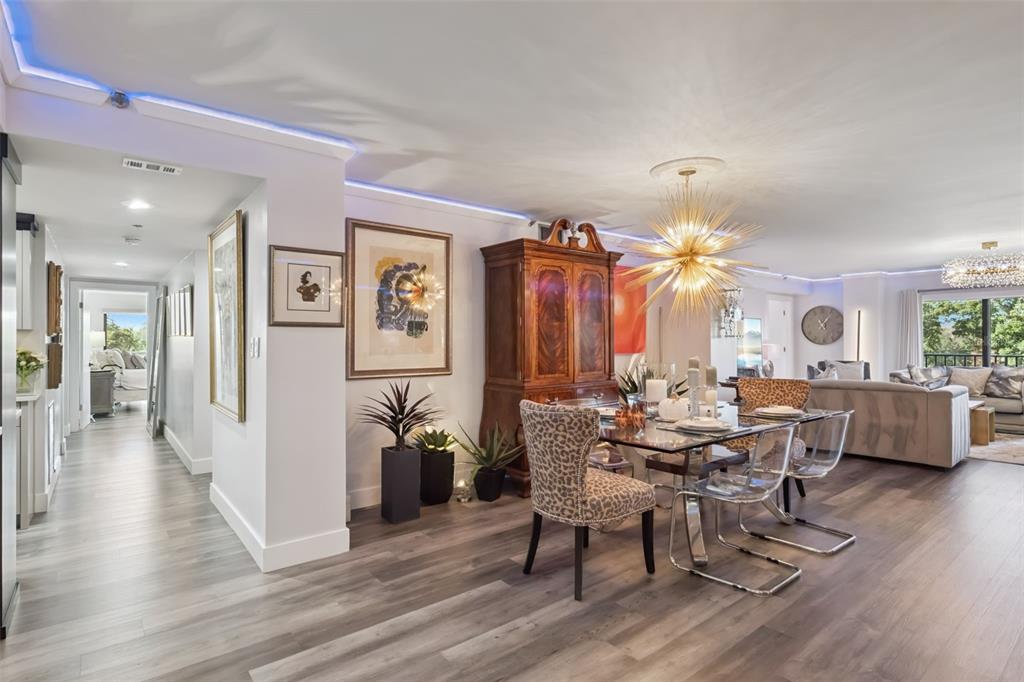 A dining area with a glass table, leopard-print chairs, and a large starburst chandelier — 7550 HINSON STREET UNIT 4b, ORLANDO, FL