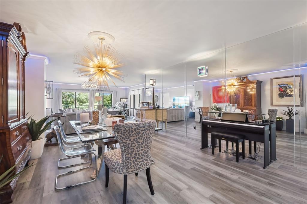 A dining area with a starburst chandelier, glass table, leopard-print chair, and mirrored wall panels — 7550 HINSON STREET UNIT 4b, ORLANDO, FL