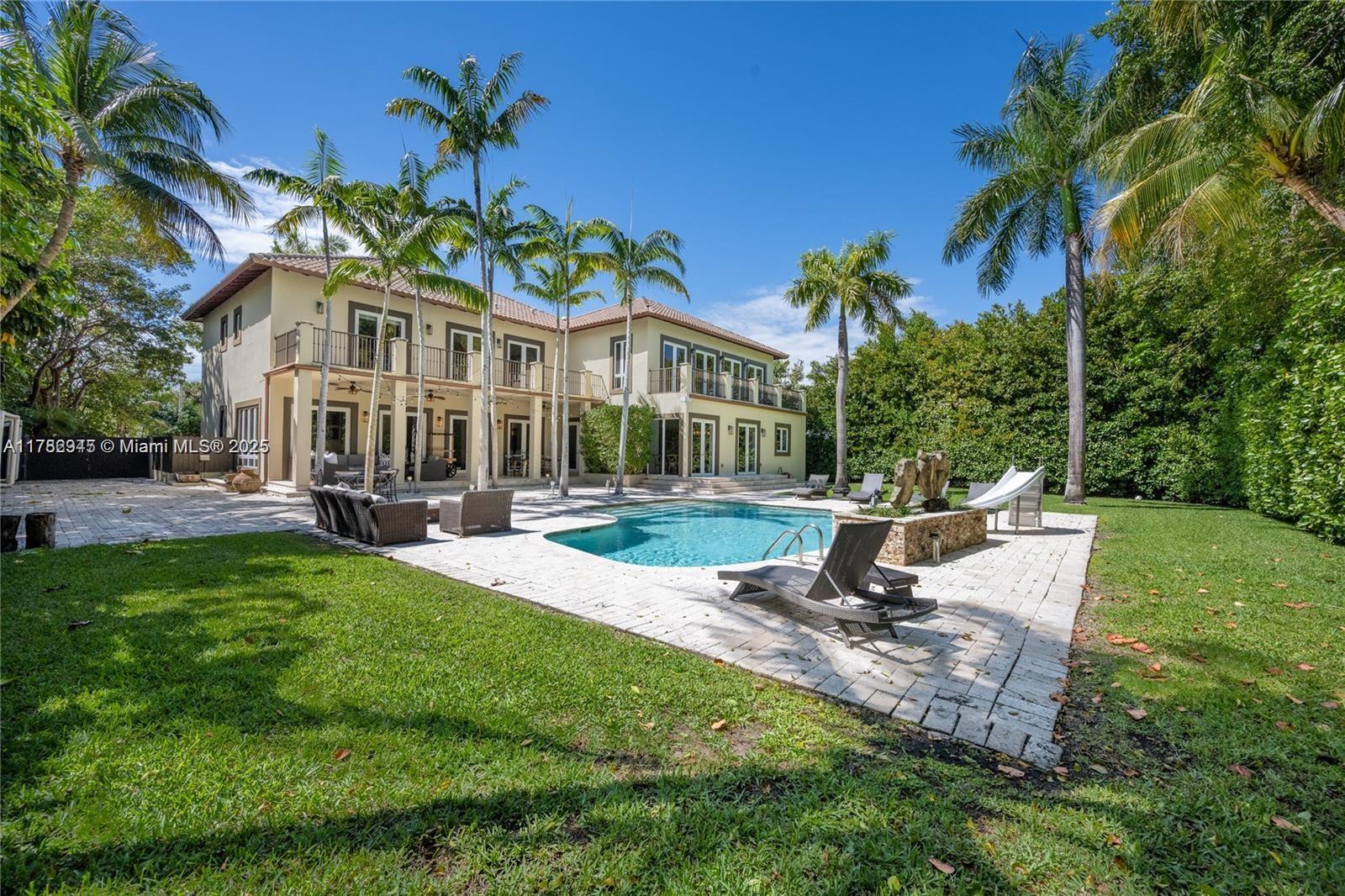 A backyard patio features a swimming pool, lounge chairs, and outdoor wicker furniture — 31 Island Dr, Key Biscayne FL 33149, KEY BISCAYNE, FL