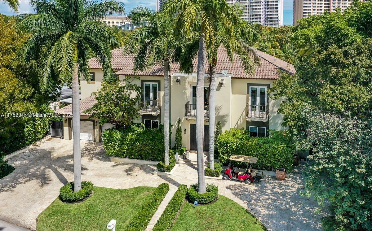 An aerial view of a two-story house with a paved driveway, palm trees, and golf cart — 31 Island Dr, Key Biscayne FL 33149, KEY BISCAYNE, FL