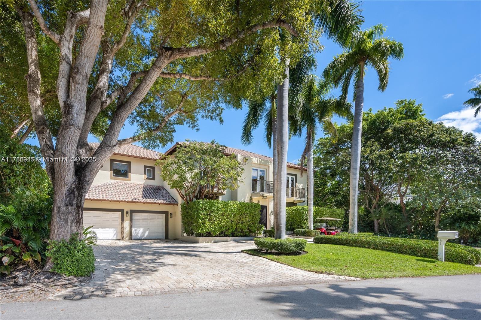 A two-story house with a paved driveway, a two-car garage, and tall palm trees — 31 Island Dr, Key Biscayne FL 33149, KEY BISCAYNE, FL