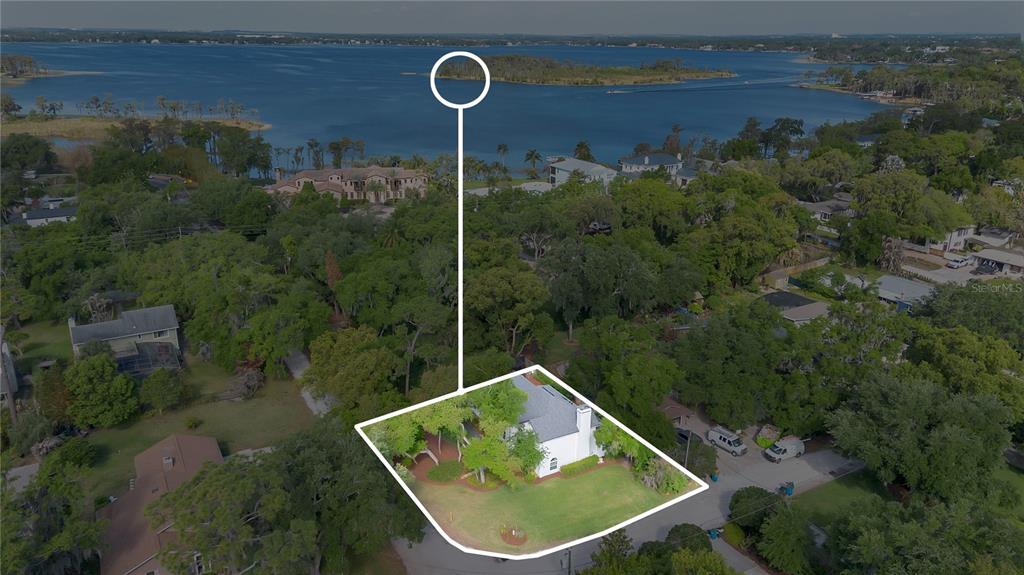 An aerial view shows a white house with a large yard near a lake — 109 E 12TH AVENUE, WINDERMERE, FL