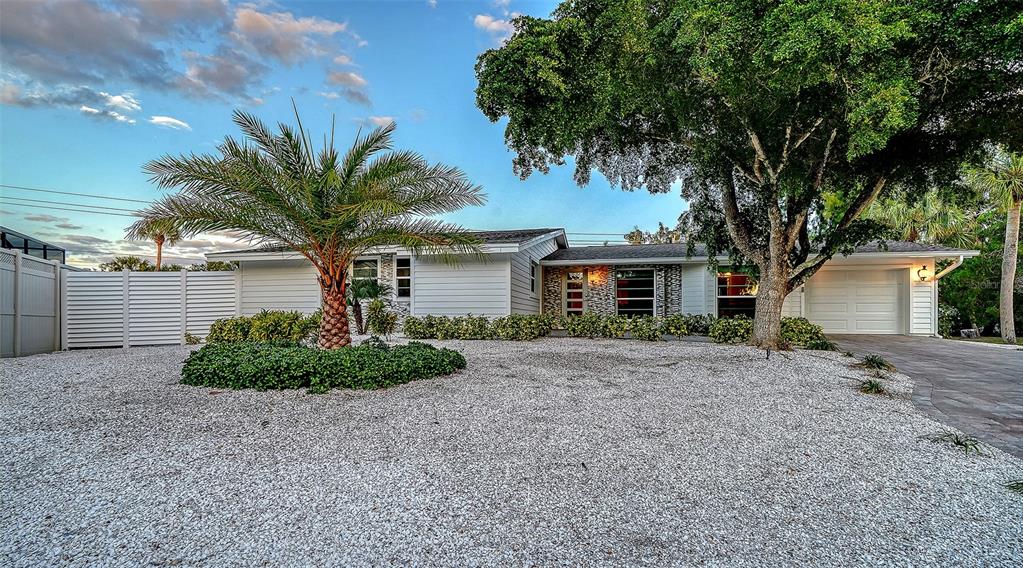 A single-story house with white siding, a gravel front yard, and a large tree — 783 BIRDSONG LANE, SARASOTA, FL