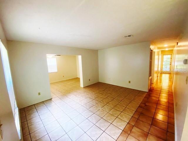 An interior view shows a tiled living area leading into a hallway with light-colored walls — 101 S FLAMINGO AVENUE, WINTER SPRINGS, FL