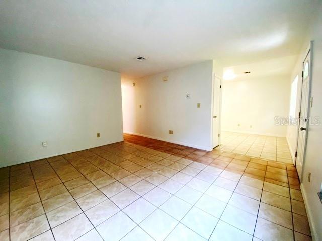 An interior view shows a room with light-colored walls and beige tiled flooring — 101 S FLAMINGO AVENUE, WINTER SPRINGS, FL