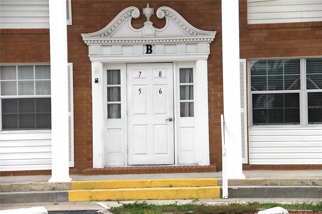 The exterior entrance to building B features a white door with unit numbers displayed — 4158 TAMIAMI TRAIL UNIT B6, PORT CHARLOTTE, FL