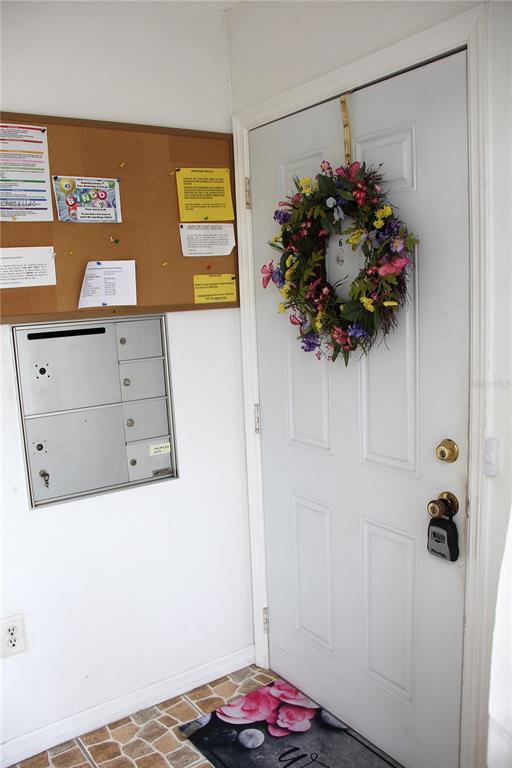 An entryway features a white door with a floral wreath, mailboxes, and a corkboard — 4158 TAMIAMI TRAIL UNIT B6, PORT CHARLOTTE, FL
