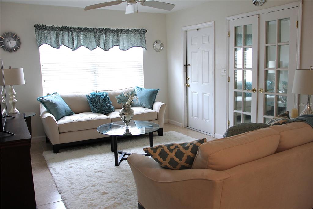 A living room features two beige sofas, a glass coffee table, and a white rug — 4158 TAMIAMI TRAIL UNIT B6, PORT CHARLOTTE, FL