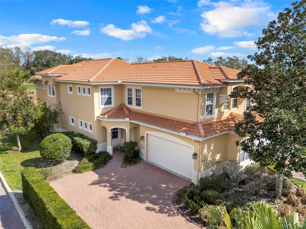 An aerial view of a two-story stucco house with a tile roof and brick driveway — 26206 AVENIDA LAS COLINAS UNIT 4A, HOWEY IN THE HILLS, FL