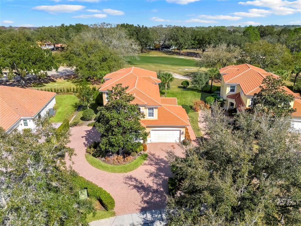 An aerial view shows a two-story house with a tile roof and a paved driveway — 26206 AVENIDA LAS COLINAS UNIT 4A, HOWEY IN THE HILLS, FL