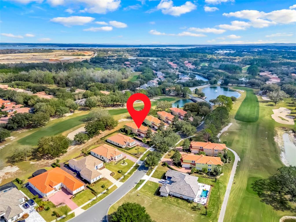 An aerial view shows a residential neighborhood with houses situated along a golf course — 26206 AVENIDA LAS COLINAS UNIT 4A, HOWEY IN THE HILLS, FL
