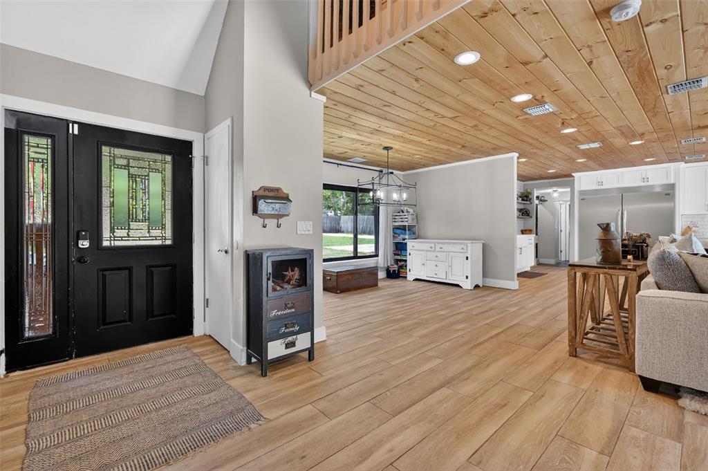 An entryway with a black door, wood-look tile flooring, and a wood-paneled ceiling — 32589 OKALOOSA TRAIL, SORRENTO, FL