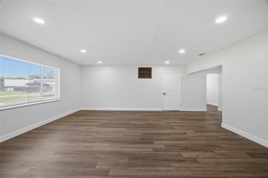 A spacious room with white walls, recessed lighting, and wood-look vinyl plank flooring — 3502 LILES LANE, PLANT CITY, FL