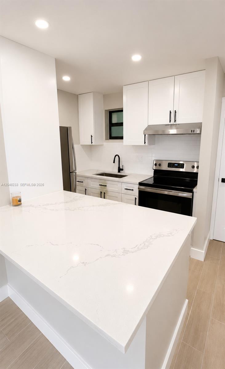 A modern kitchen features white cabinets, quartz countertops, and stainless steel appliances — 1530 SW 2nd St # 307, Miami FL 33135, MIAMI, FL