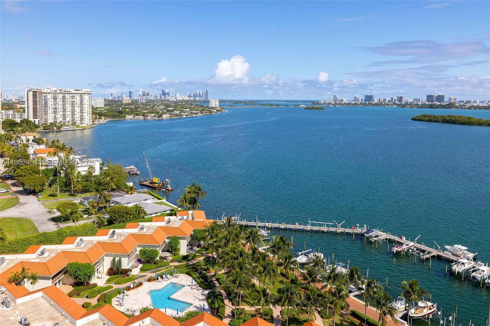 An aerial view shows a waterfront residential complex with a pool, docks, and boats — 4000 Towerside Ter # 2005, Miami FL 33138, MIAMI, FL