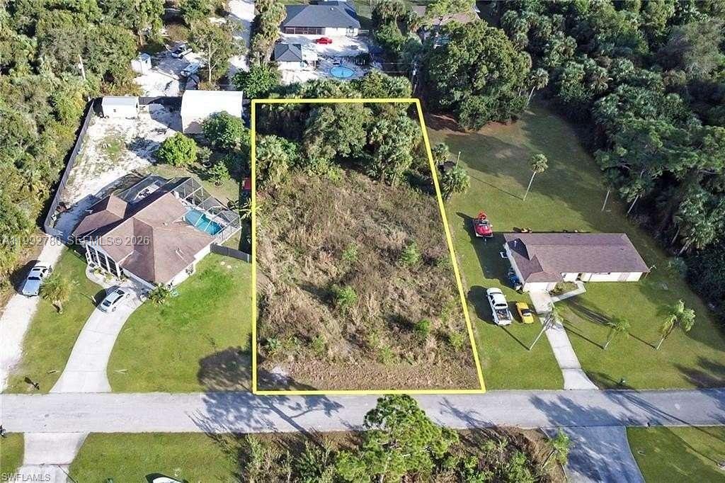 An aerial view shows a rectangular vacant lot outlined in yellow between two residential houses — 1140 Cummings ST E, Lehigh Acres FL 33974, LEHIGH ACRES, FL