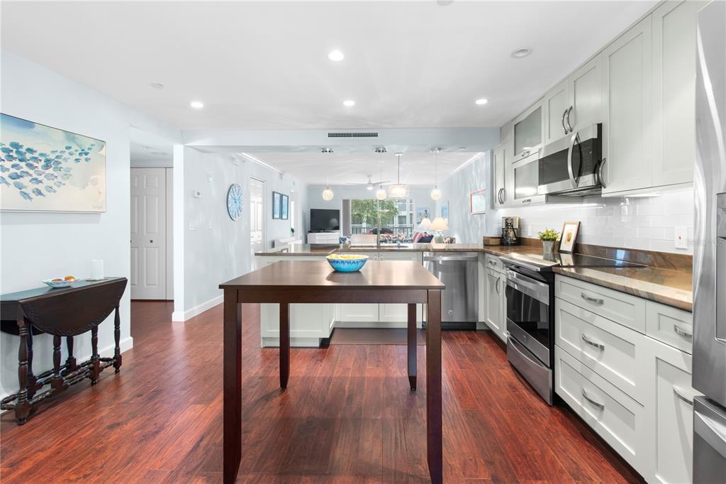 A kitchen with light gray cabinets, stainless steel appliances, and a central wooden island — 9320 CLUBSIDE CIRCLE UNIT 2201, SARASOTA, FL
