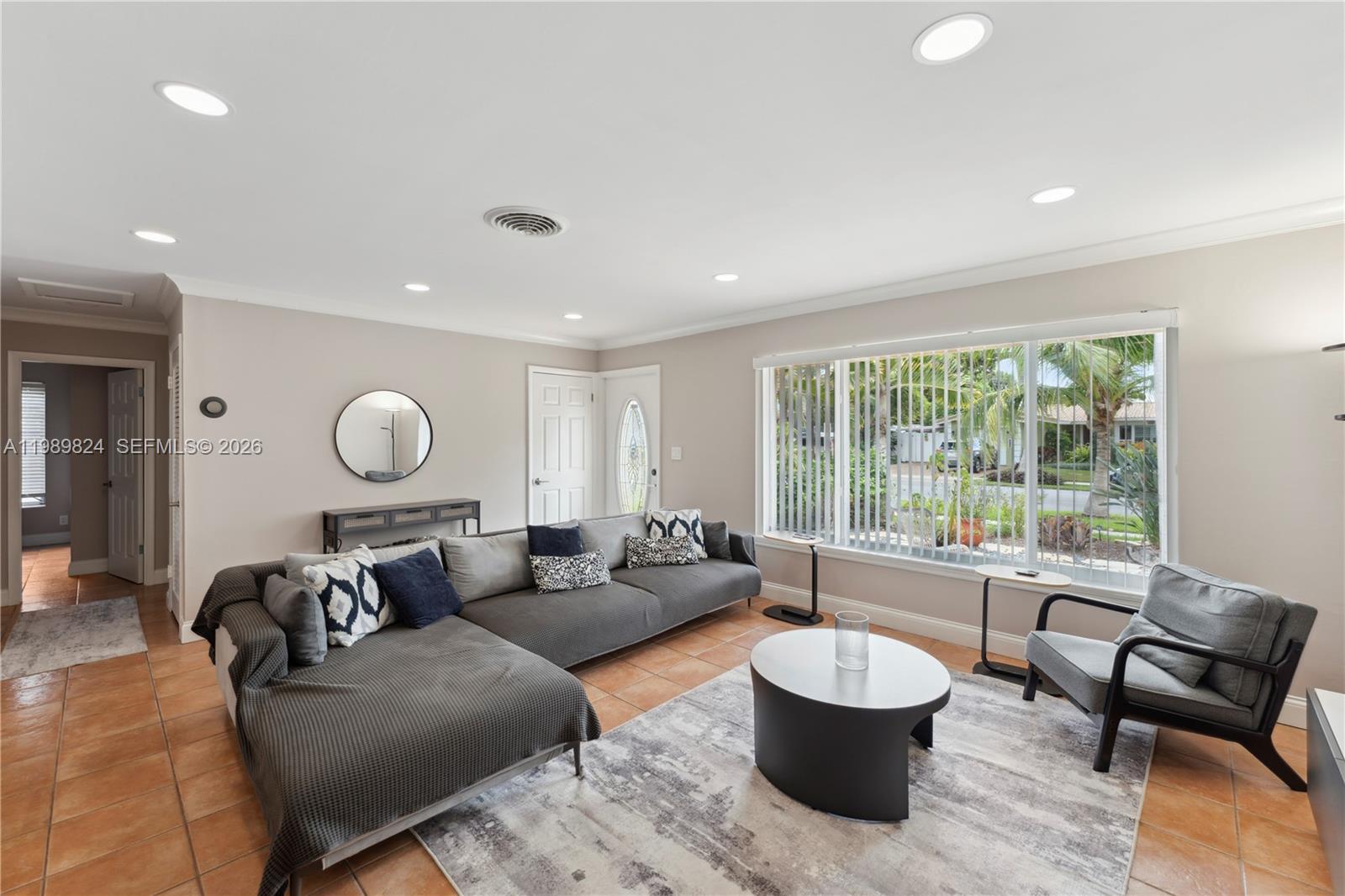 A living room features a grey sectional sofa, a round coffee table, and tile flooring — 1111 SW 5th St, Boca Raton FL 33486, BOCA RATON, FL