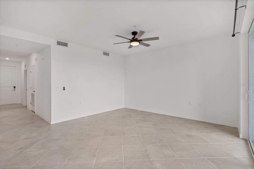 An empty room with white walls, tile flooring, and a ceiling fan — 14161 HERITAGE LANDING BOULEVARD UNIT 1123, PUNTA GORDA, FL